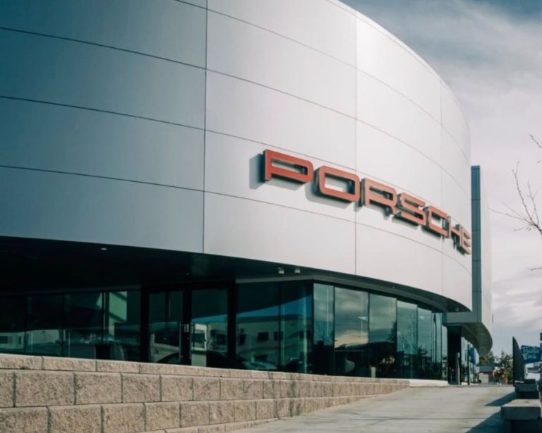 Denver West Porsche building exterior with silver walls and red logo.