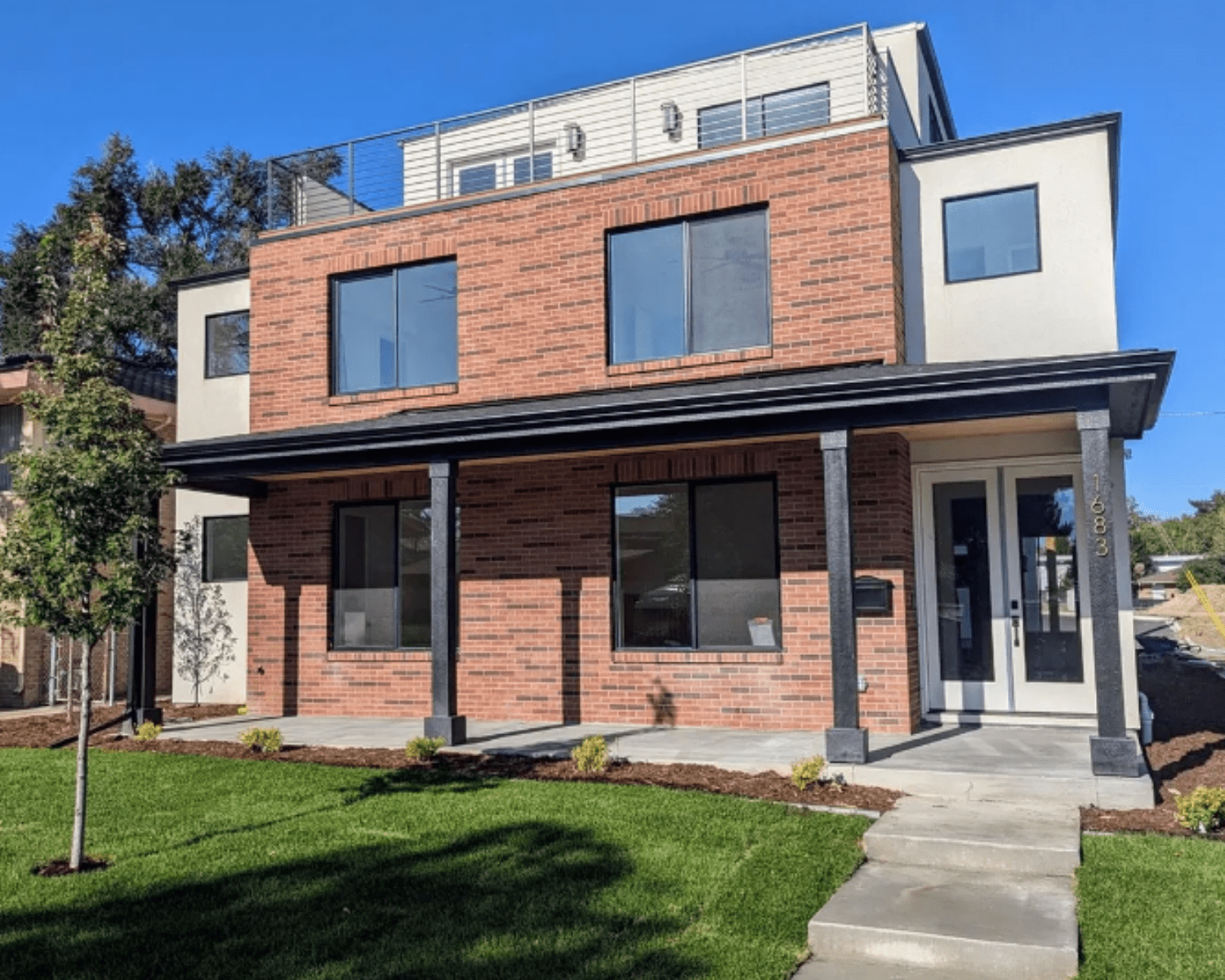 1683-W-ZENOBIA-ST-DENVER-CO Image of a modern luxury home with brick, large glass windows, and rooftop patio.
