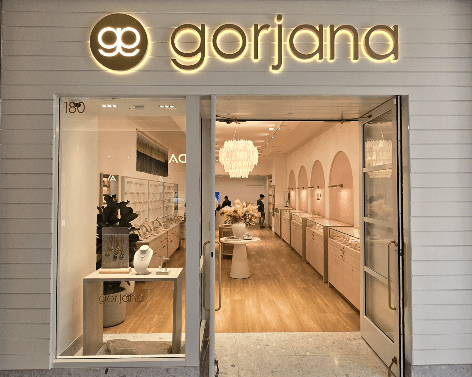 GORJANA-DENVER-CHERRY-CREEK Image of a contemporary and simple jewelry store inside of mall with entrance, sign, and arched displays.