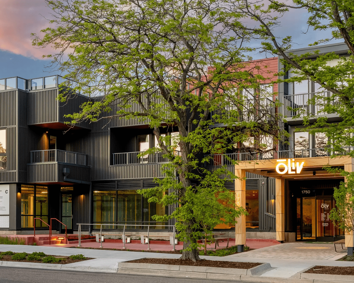 OLIV-BOULDER-1 Image of a three-story modern apartment building with large windows and metal bar balconies.