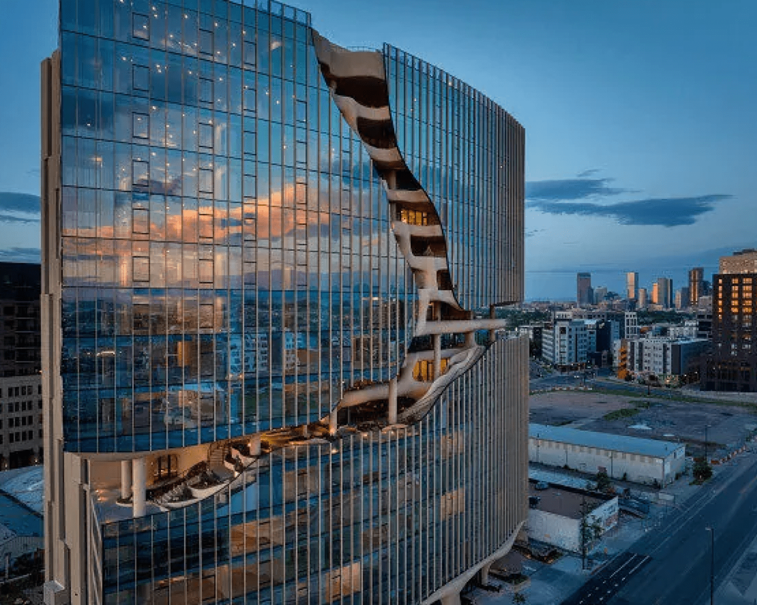 ONE-RIVER-NORTH-1 Image of the One River North luxury condo building at dusk with glass windows, funky details, and reflection of mountains.