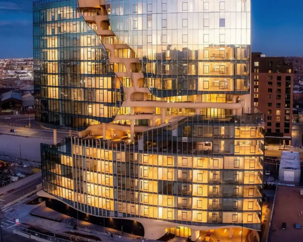Image of a front aerial view of One River North at night in Denver, Colorado.