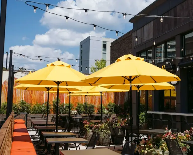 Image of Postino Ballantyne exterior with yellow umbrellas.