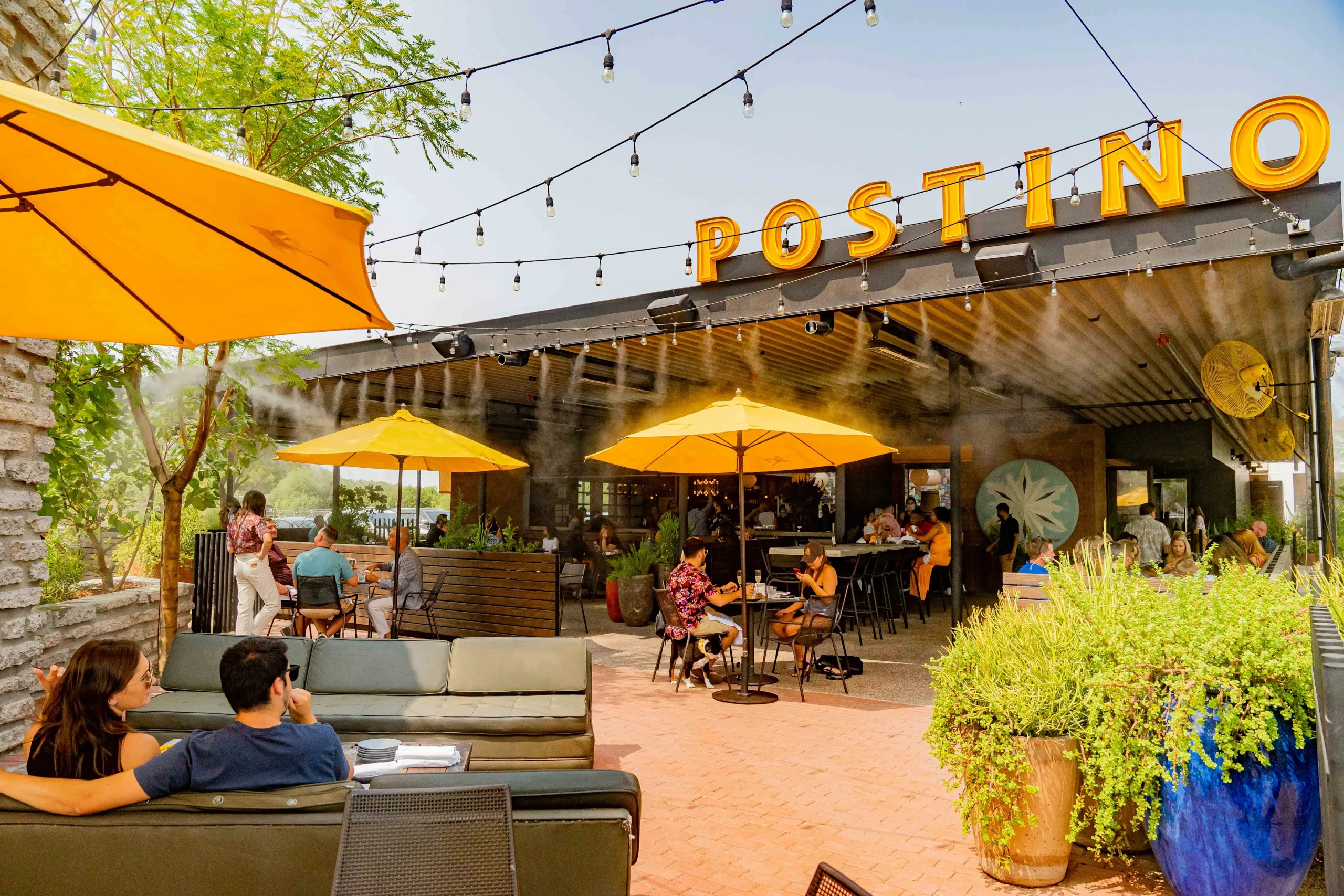 POSTINO-WESTMINSTER-RENDERING Image of Postino Westminster exterior rendering showing the outdoor and indoor style of the restaurant with yellow umbrellas.