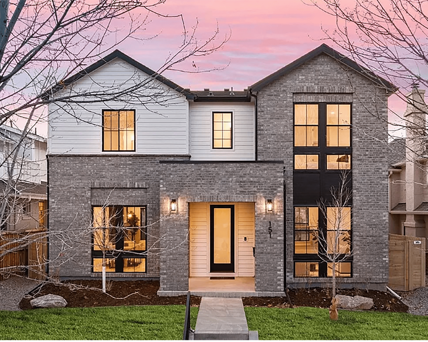 SOUTH-HUMBOLDT-DENVER-CO Image of a modern two-story luxury home with brick, siding, and large glass windows.