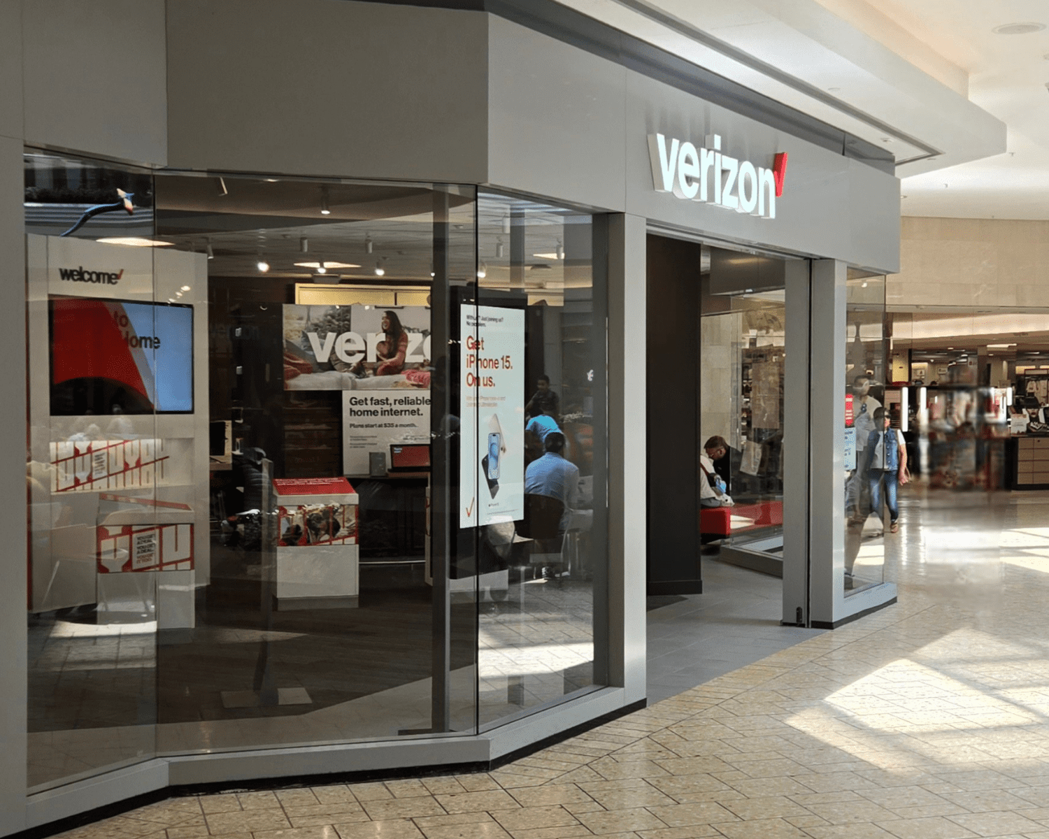 VERIZON-DENVER-CHERRY-CREEK Image of a Verizon retail store inside of a mall with tall glass windows and open entrance.