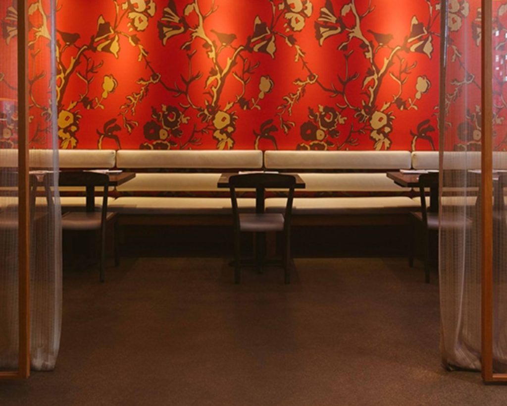 Uchiko Denver interior with vibrant red Japanese floral wallpaper and modern seating.